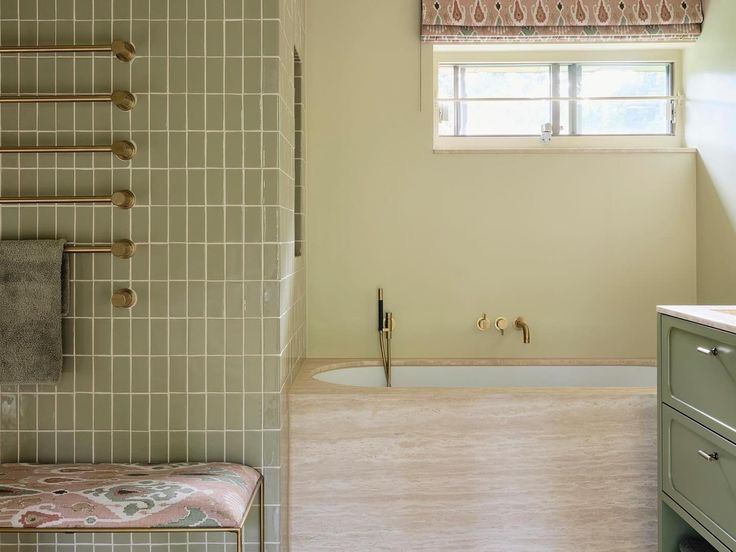 a bathroom with a tub, sink and window