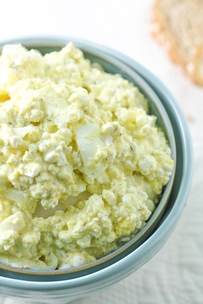 a glass bowl filled with cottage cheese and a metal whisk in it's center