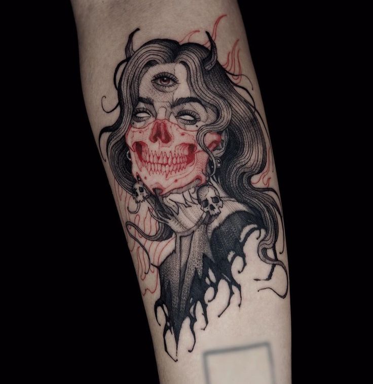 a woman's arm with a tattoo on it and a skull in the middle