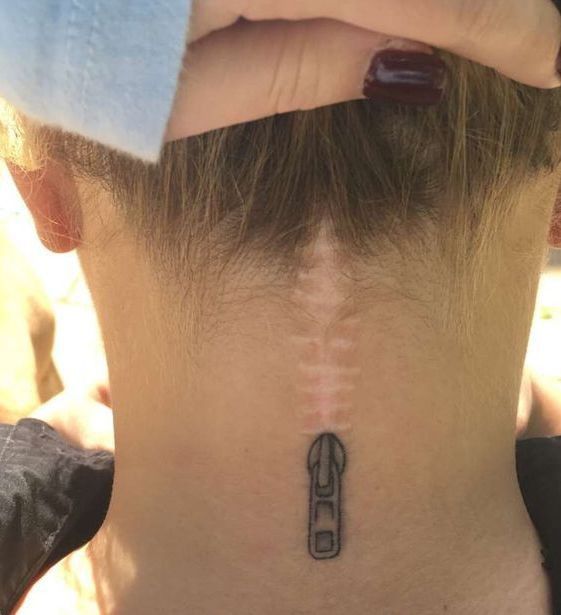 the back of a woman's neck with an arrow tattoo on it