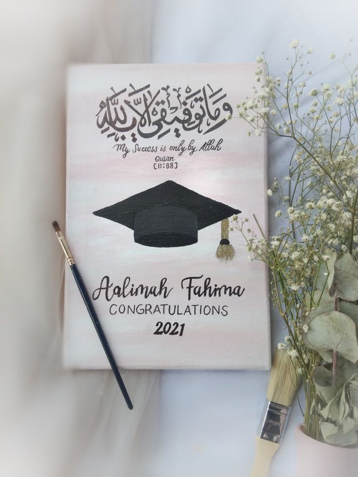 a book with a graduation cap on it next to flowers