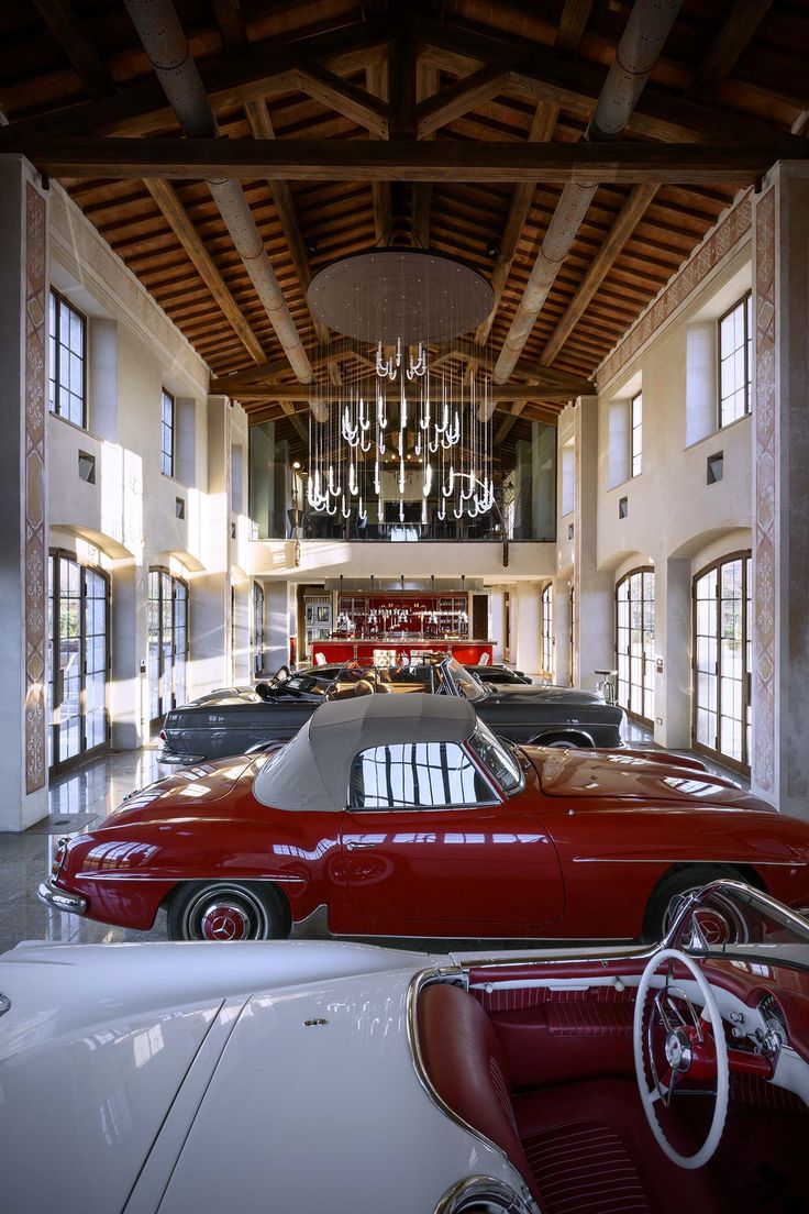 the inside of a building with several cars parked in it and chandeliers hanging from the ceiling