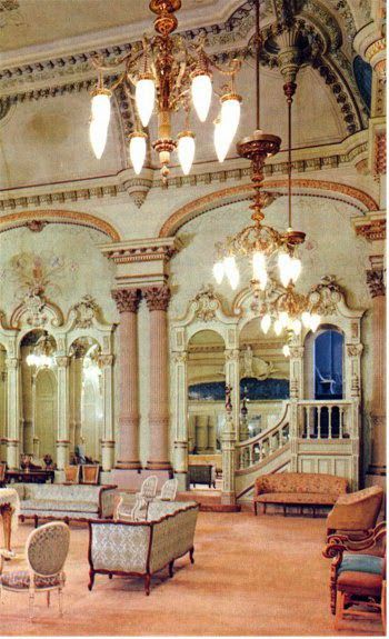 an ornately decorated room with chandeliers and couches