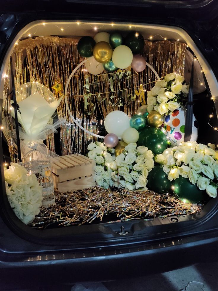 the trunk of a car is decorated with flowers and balloons