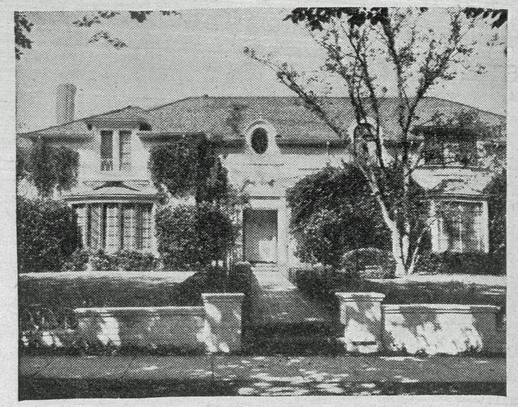 an old black and white photo of a large house with trees in the front yard