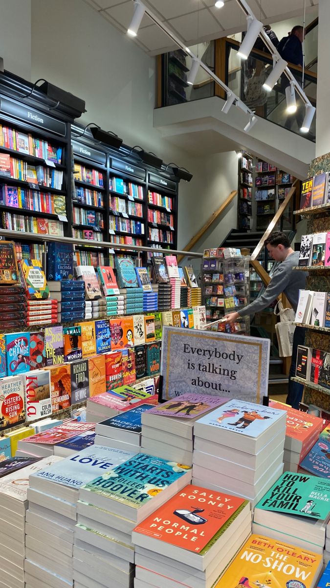 many books are stacked on top of each other in front of a book store display