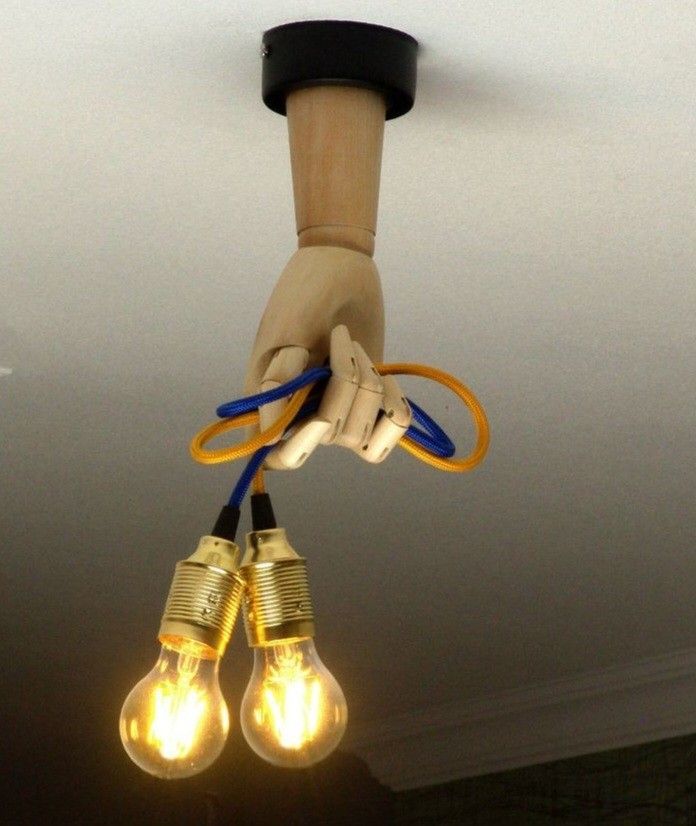 two light bulbs are being held up by a hand with some wires attached to them