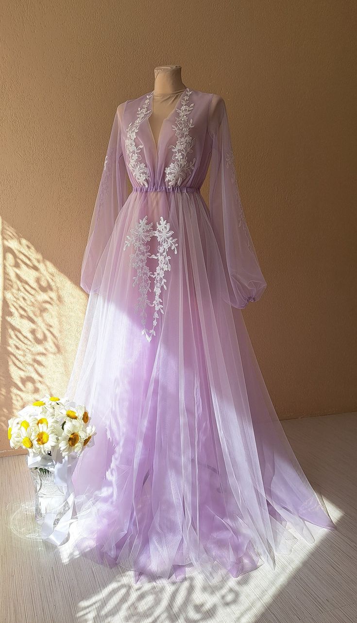 a dress is displayed on a mannequin next to flowers