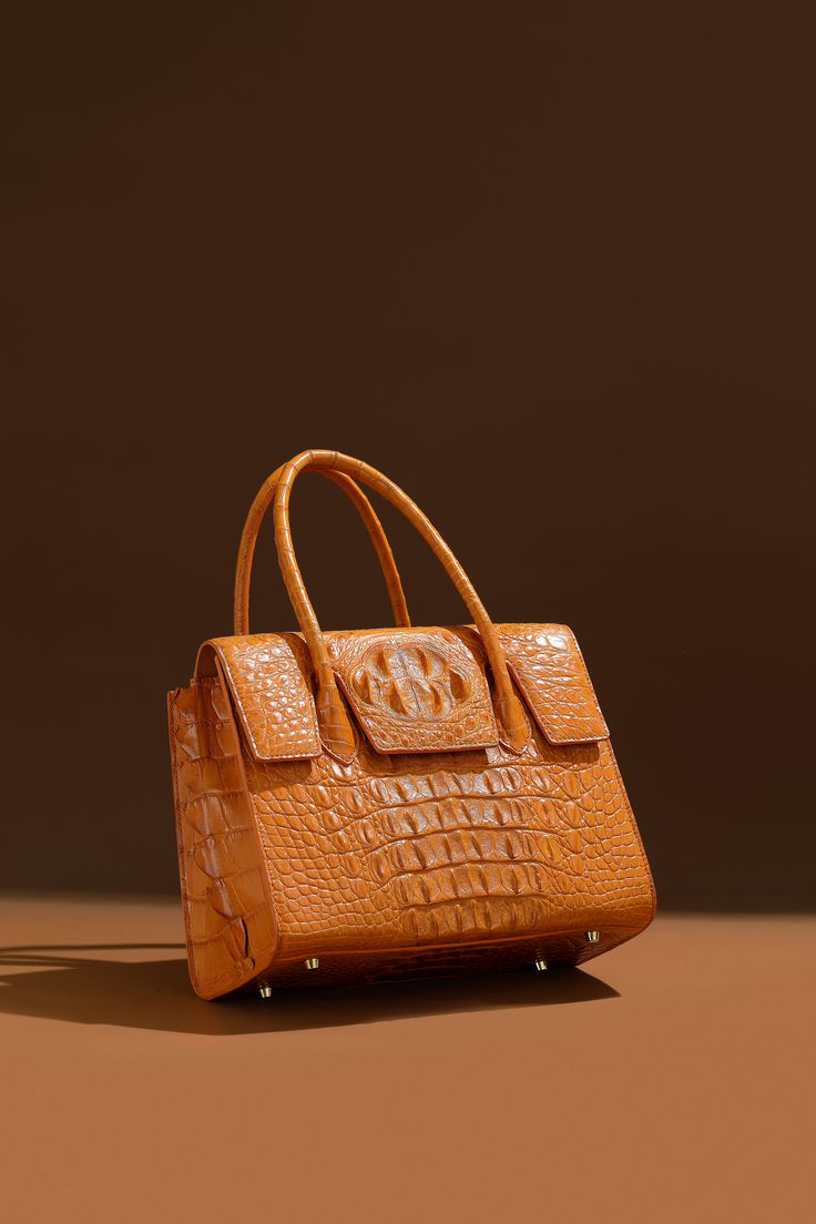 FashionByTeresa LETO Satchel Handbag Introducing the Leto Handbag – a symphony of style and sophistication for the contemporary fashion aficionado. Crafted from the finest crocodile-embossed leather, this handbag is a masterpiece that combines luxury with practicality. Its sumptuous cognac shade adds a touch of aristocratic charm to any attire, making it a versatile addition to both daywear and evening outfits. Description: Real Crocodile Satchel Handbag made of real crocodile hornback skin, Metal Stainless Steel Gold or Silver Size: 31*23*13 CM/ 12.2 x 9.06 x 5.12 inches MODEL #: Lfbt24001 Open top with magnetic closure Lamb skin Interior, zip pouch Top zipper closureLuxury quality hardware The interior features a zipper pocket, phone, and doc. pocket Hand Sawn Rolled shoulder straps The Hand Saw, Satchel Handbag, Evening Outfits, How To Make Handbags, Greek Goddess, Satchel Handbags, Zip Pouch, Open Top, Contemporary Fashion