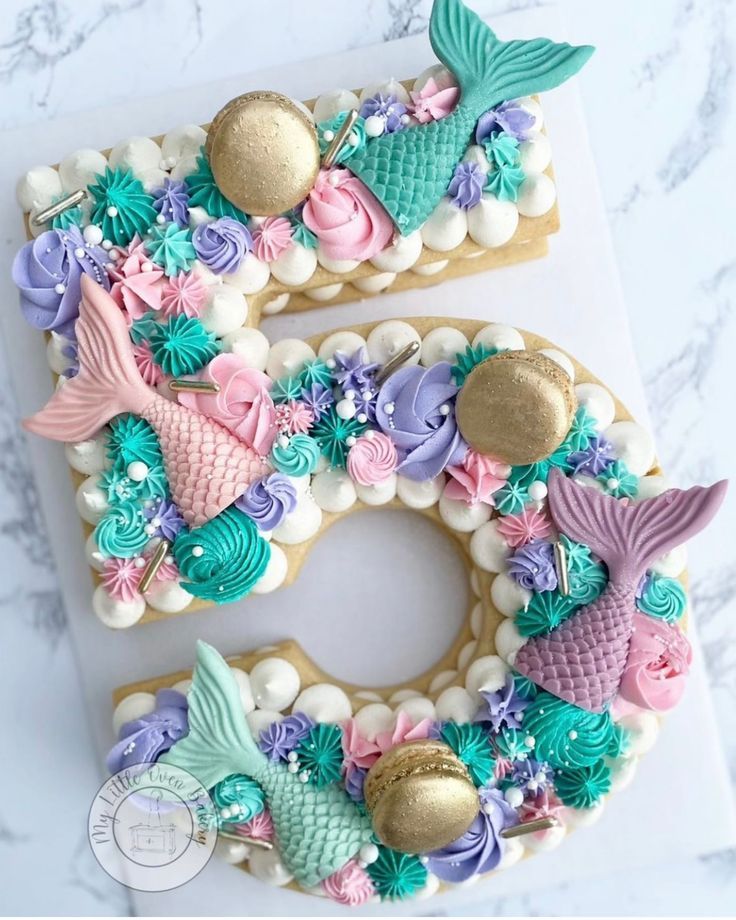 the number five is made out of cookies and decorated with mermaid decorations