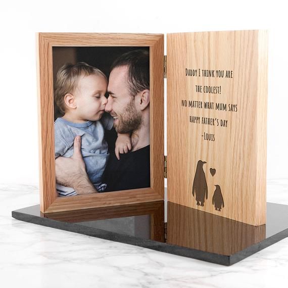 a wooden photo frame with an image of a man holding a baby