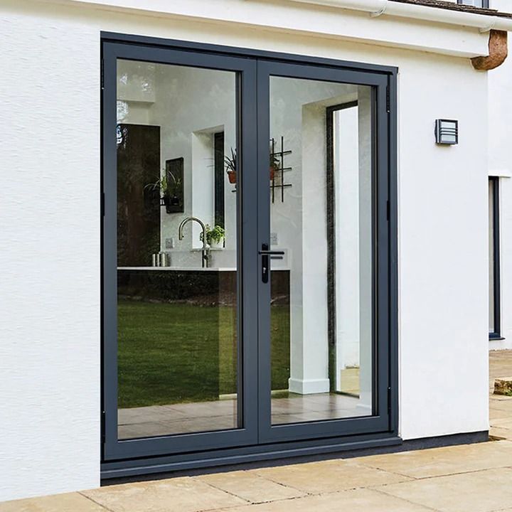 a white house with black double doors and glass windows on the front door is shown