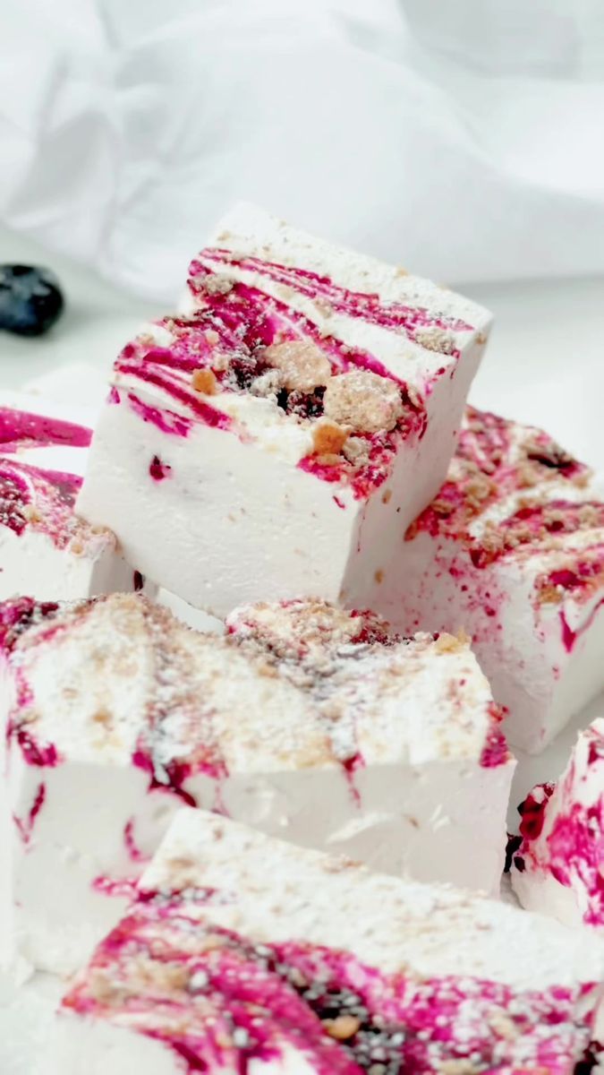 several pieces of cake sitting on top of each other with blueberries in the background