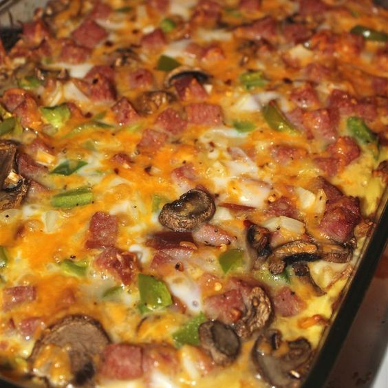 a casserole dish with sausage, mushrooms and peppers