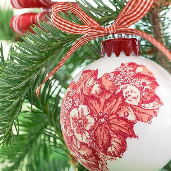 a red and white ornament hanging from a christmas tree with ribbon on it