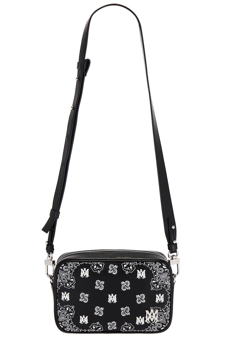 Find AMIRI Bandana Camera Case Bag on Editorialist. Amiri Bandana Camera Case Bag in Black Leather exterior with Amiri logo detail embroidered and ripstop lining. Made in Italy. Top zipper closure. One main compartment. Detachable shoulder strap. Measures approx 7.5 W x 5 H x 2 D Shoulder strap with a 16.5 drop. AMIF-MY70. AMBGCM1006. About the designer: Mike Amiri's eponymous label fuses rock and roll with haute couture. Deriving its inspiration from Amiri's upbringing in Hollywood, the Califor Luxury Leather Shoulder Bag With Embroidered Logo, Luxury Embroidered Logo Crossbody Bag, Luxury Leather Bags With Embroidered Logo, Leather Shoulder Bag With Embroidered Logo For Travel, Black Leather Shoulder Bag With Embroidered Logo, Leather Shoulder Bag With Embroidered Logo For Everyday Use, Everyday Leather Shoulder Bag With Embroidered Logo, Leather Shoulder Bag With Embroidered Logo For Daily Use, Black Leather Bag With Embroidered Logo