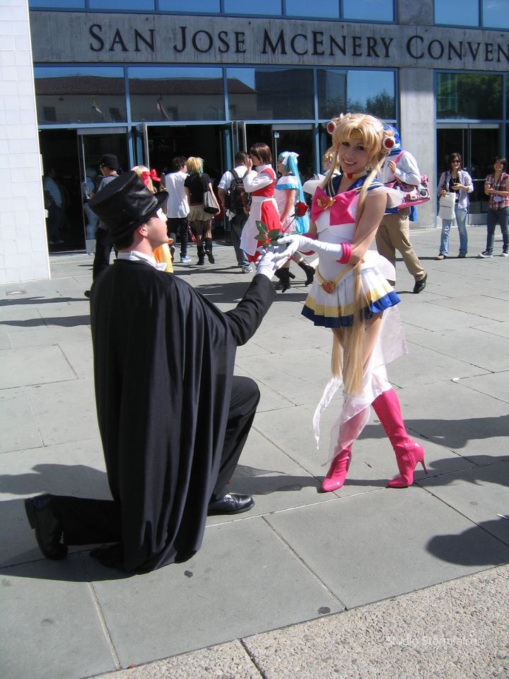 a man kneeling down next to a woman in costume