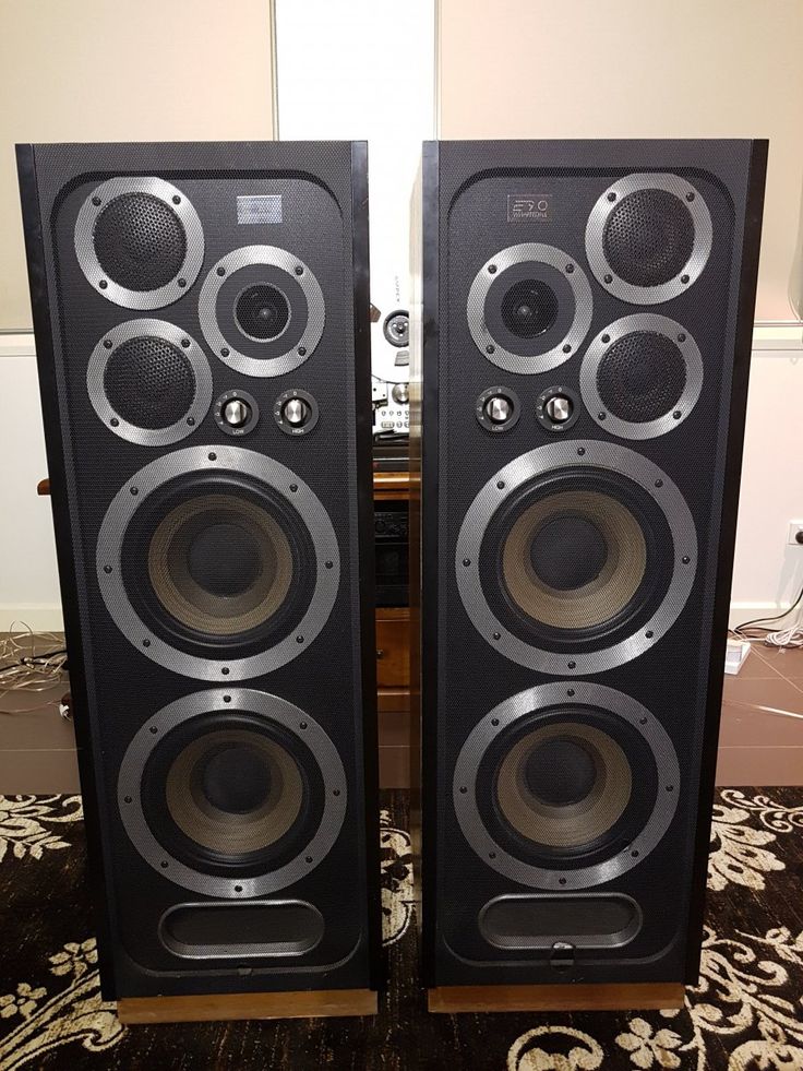 two speakers sitting side by side on top of a rug