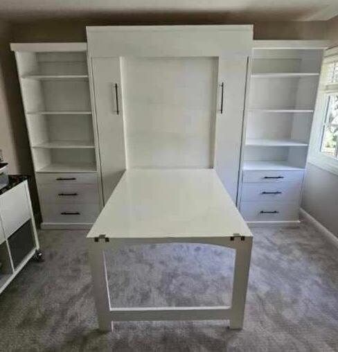 an empty room with white furniture and shelves on the walls, carpeted flooring