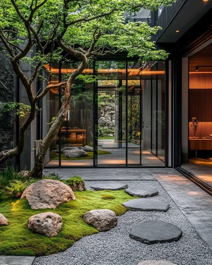 an outdoor area with rocks, grass and trees in the center is lit up by lights