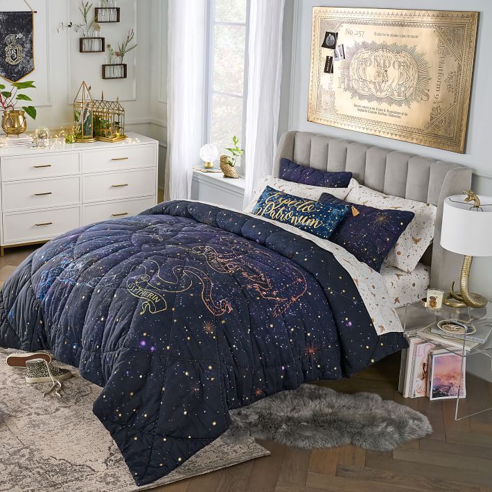 a bed room with a neatly made bed and a night sky comforter on it