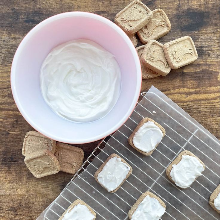 a bowl of whipped cream next to some cookies