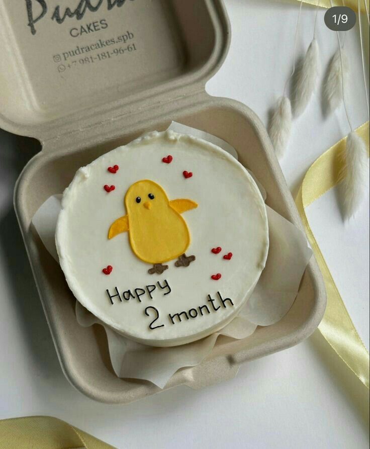 a cake in a box with a yellow bird on it