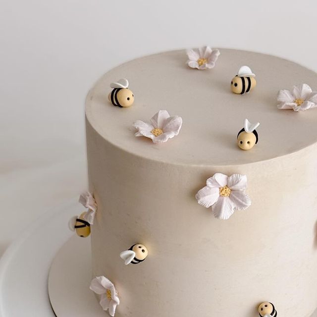 a white cake topped with lots of little bees on top of it's icing