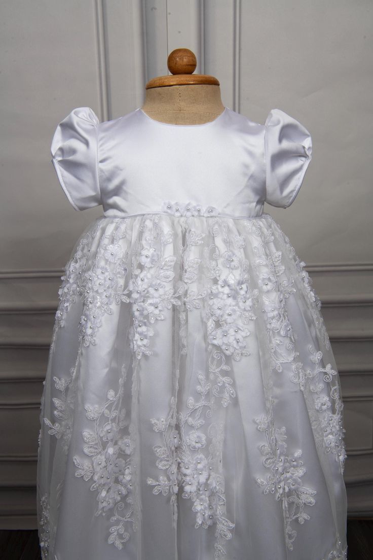 Christening gown for baby girls Gown length: 31 inches Color: white Embroidery: Beads and 3d flowers Fabric: Lace and Satin Underlay - 2 layers, satin and cotton Weight - Lightweight Sleeve - Puff sleeves Features - Floral accents on the waistline, zip closure at the back Please note: Dry clean only. Caremour promises - 1) Stress free shipping guarantee - Free expedited international shipping - Offer applicable Worldwide. Typical shipping time: 3-7 days 2) No surprise guarantee - Rest assured th White Princess Dress With Floral Applique For First Communion, Elegant Lace First Communion Dress With Floral Applique, White Floral Applique First Communion Dress, Lace Princess Dress With Floral Applique For Baptism, White Lace First Communion Dress With Floral Applique, Elegant Floral Applique Dress For Baptism, Elegant Princess Dress With Floral Applique For First Communion, Elegant First Communion Princess Dress With Floral Applique, Fitted Floral Embroidery Baptism Dresses