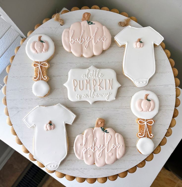 decorated cookies arranged in the shape of pumpkins and baby ones on top of a table