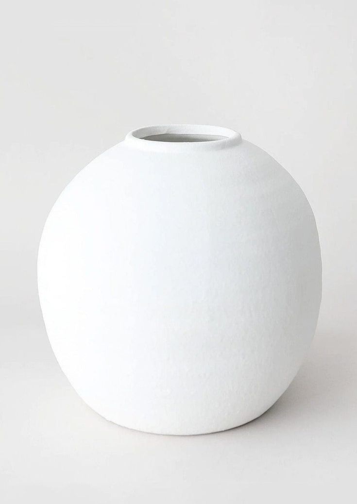 a white vase sitting on top of a table