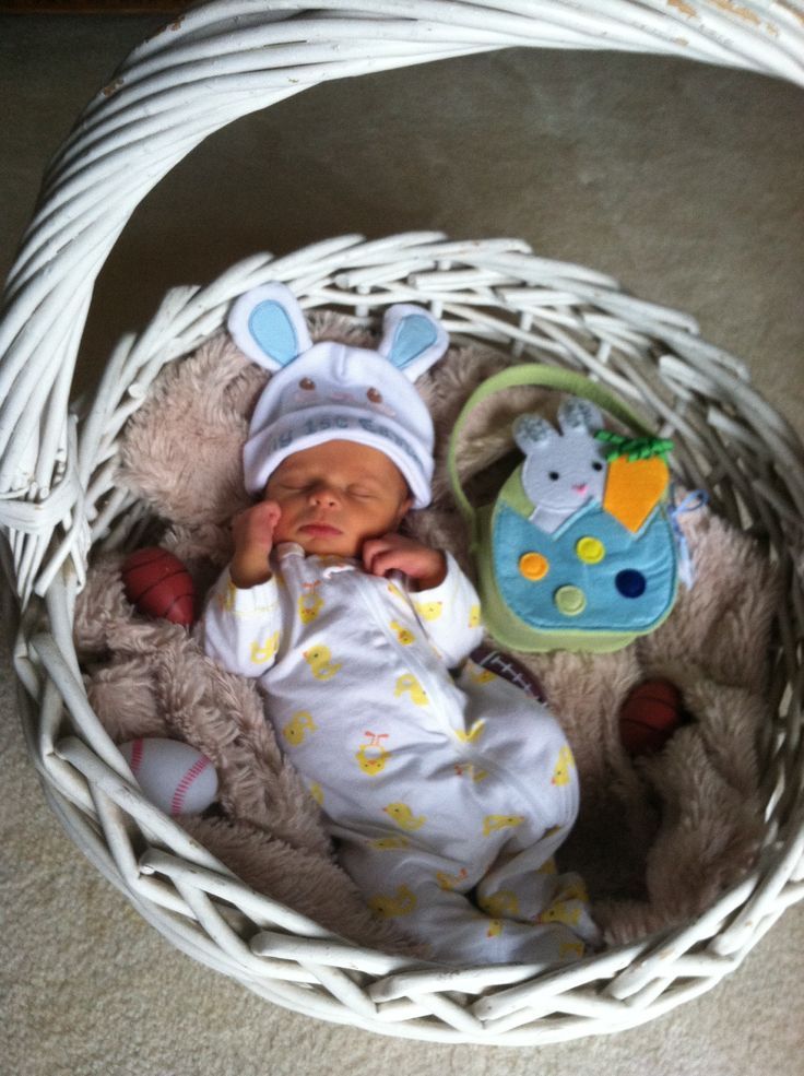 a baby is laying in a basket on the floor