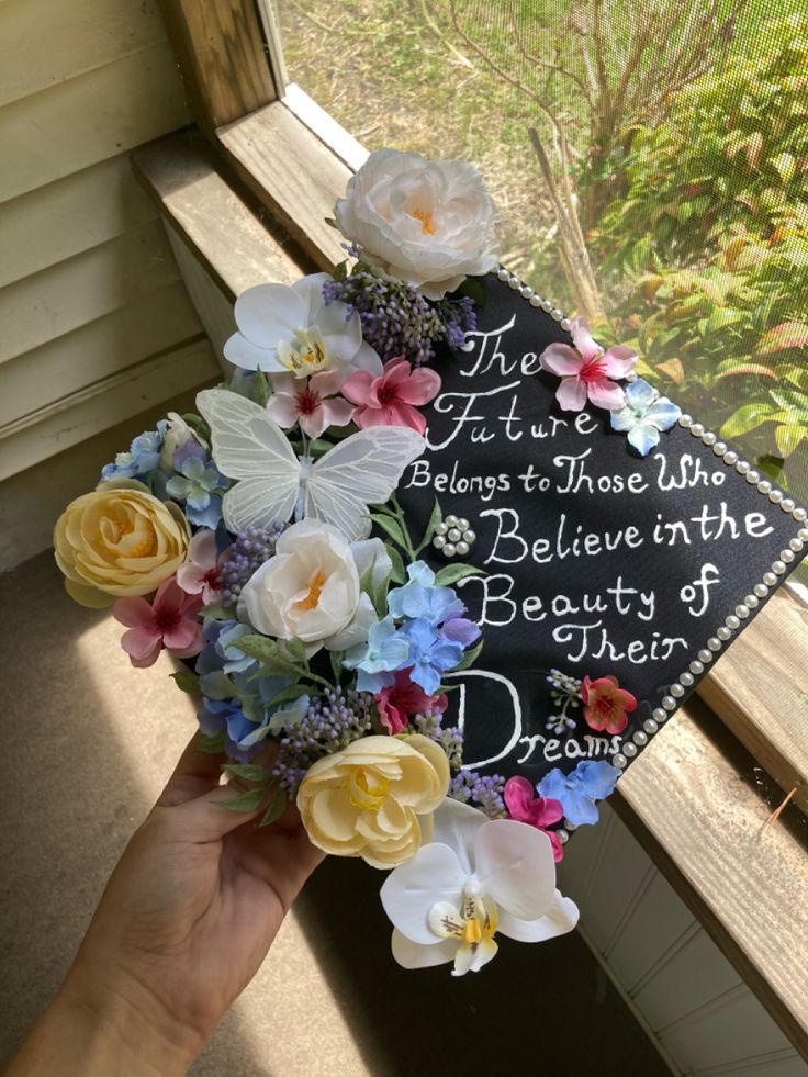 a graduation cap decorated with flowers and the words, the future belongs to those who believe in the beauty of dreams