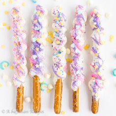 four different colored candy sticks with sprinkles on them