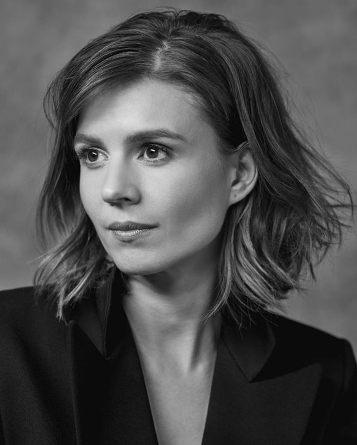 a black and white photo of a woman with shoulder length hair, wearing a suit