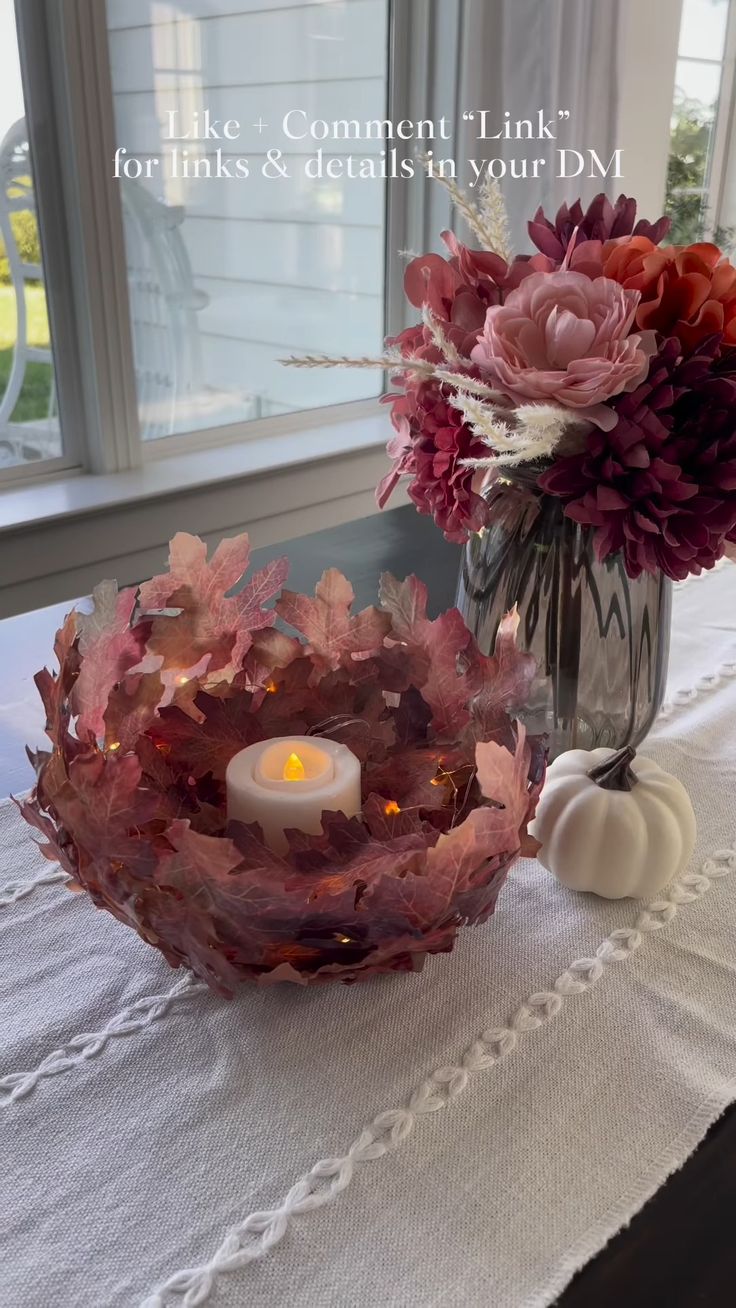 a vase with flowers and a candle on a table