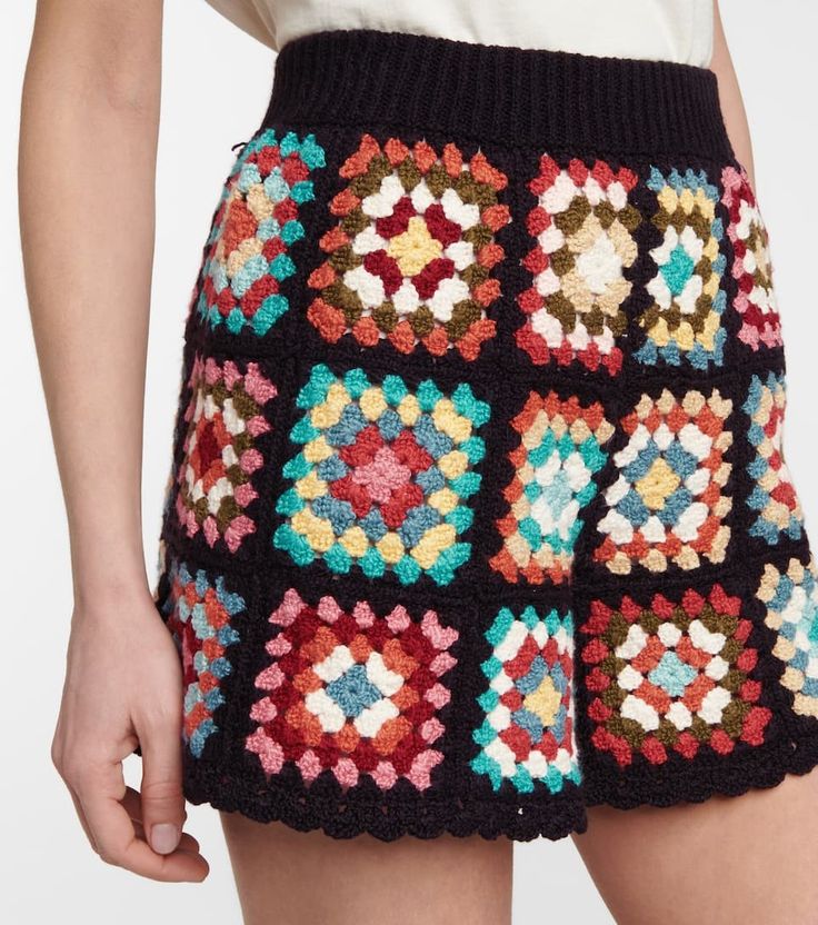 a woman is wearing a multicolored crochet skirt