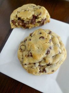 two chocolate chip cookies sitting on top of a white plate