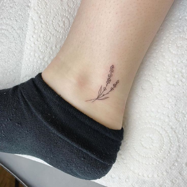 a small tattoo on the ankle of a woman's foot, with flowers in it