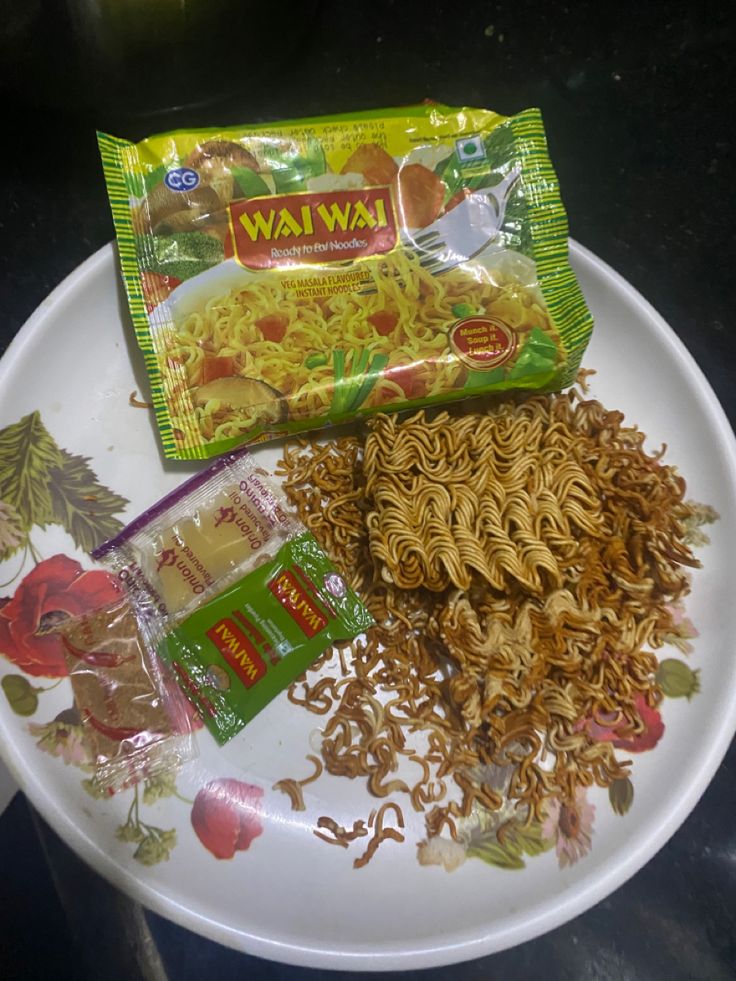 a white plate topped with noodles and veggies next to a bag of wawa