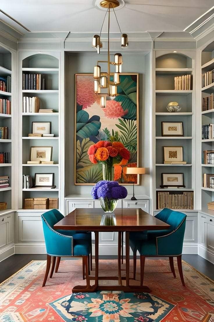 a dining room with blue chairs and a large painting on the wall