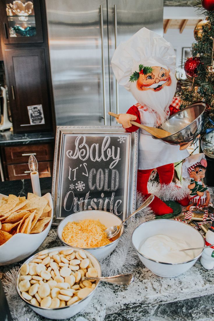 an assortment of food is displayed on the counter in front of a sign that says baby it's cold outside