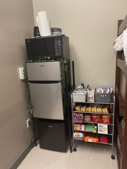 a room with a refrigerator, shelves and other items on the floor in front of it