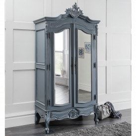 an ornate blue armoire with mirrored doors and mirror on the front, next to a rug