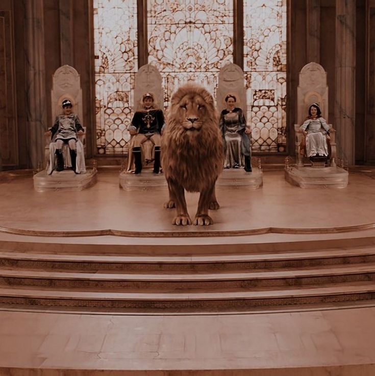 a lion is standing on some steps in front of several people sitting at the alter