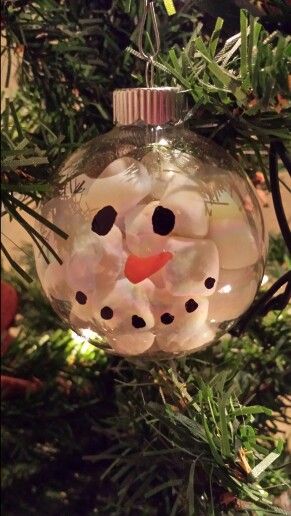 a snowman ornament hanging from a christmas tree