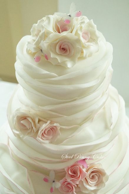 a white wedding cake with pink flowers on top