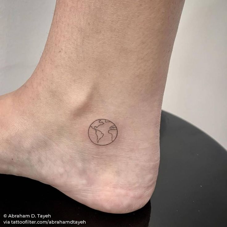 a small earth tattoo on the ankle