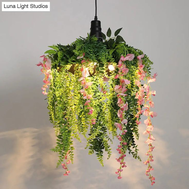 a plant hanging from a light fixture with pink flowers and green plants growing on it