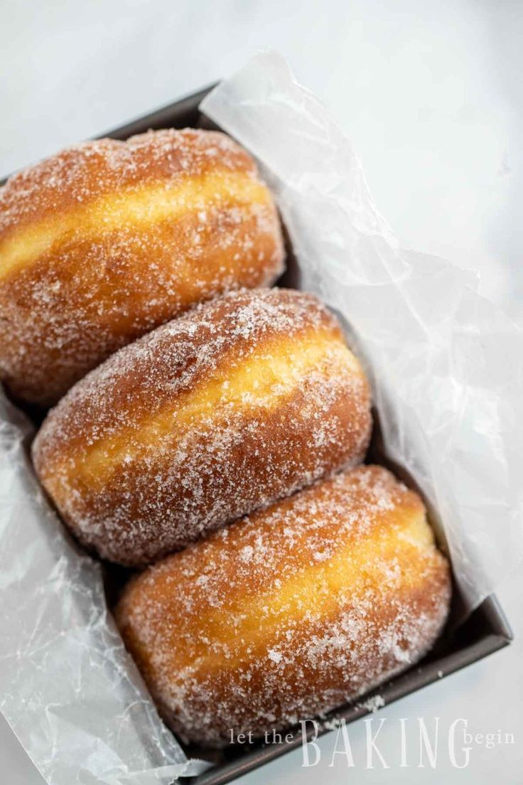 three sugar covered doughnuts in a box